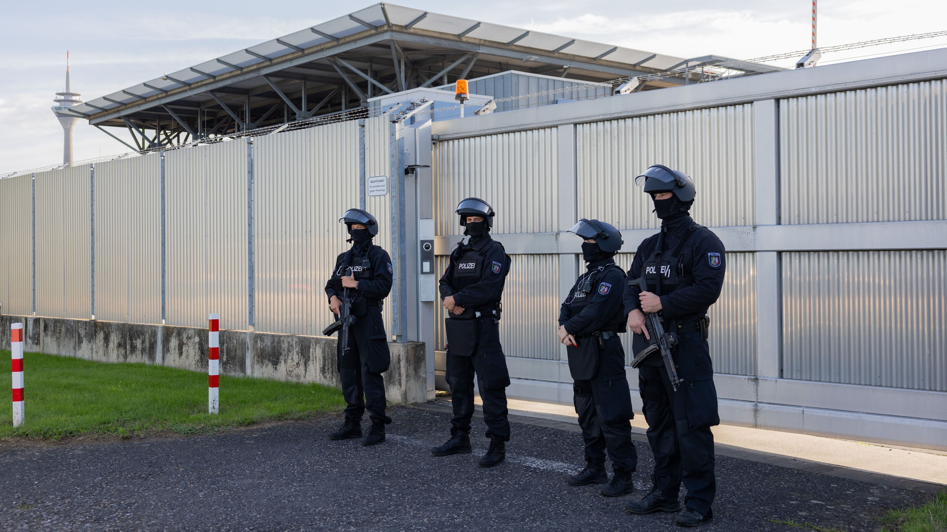 Stark bewaffnete Polizeibeamte stehen vor dem Hochsicherheitstrakt des Oberlandesgerichts.