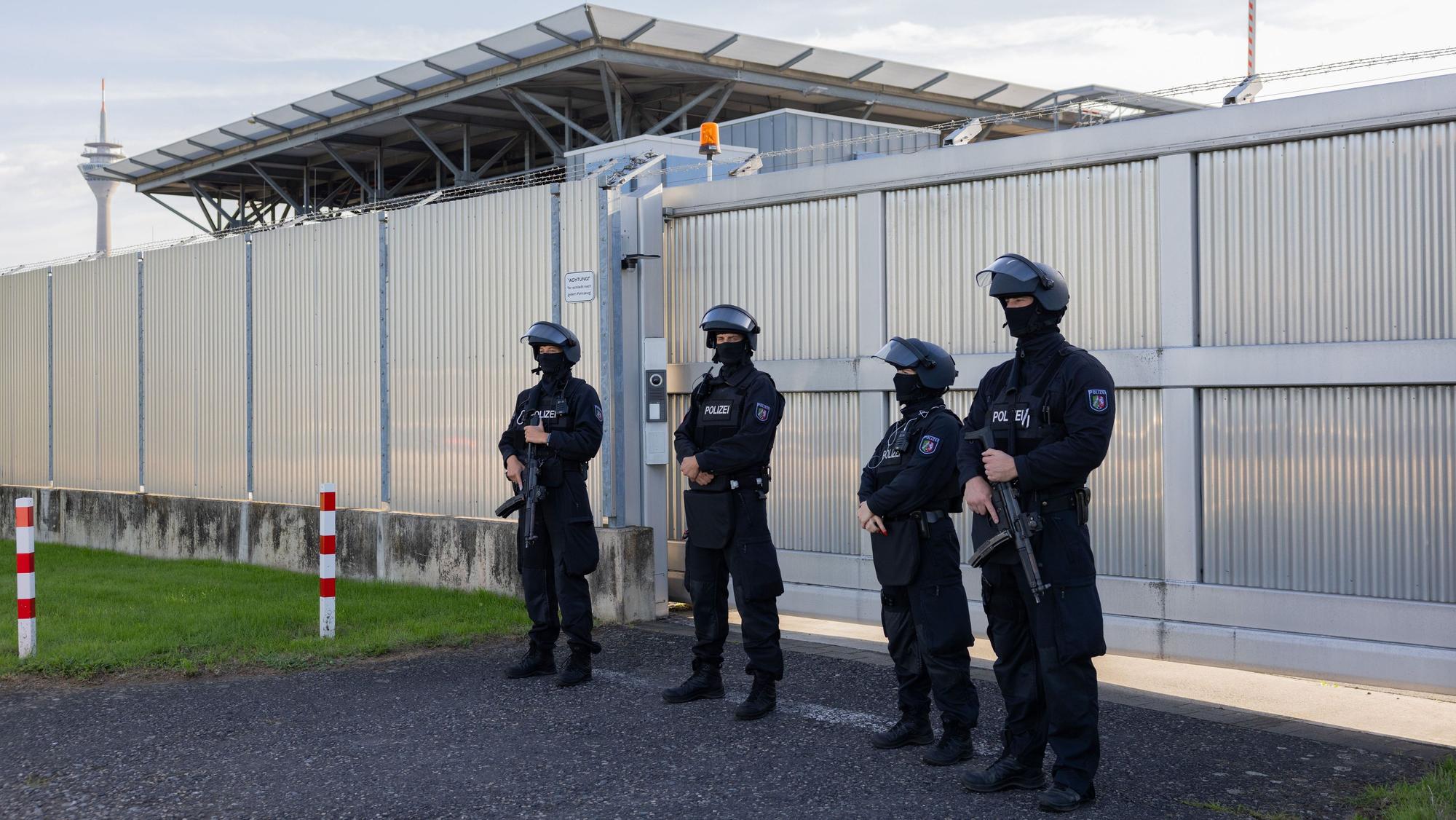 Stark bewaffnete Polizeibeamte stehen vor dem Hochsicherheitstrakt des Oberlandesgerichts.