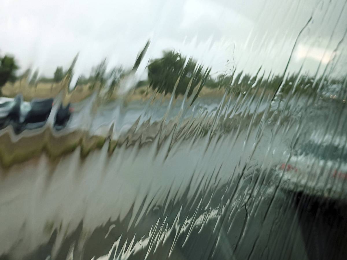Regen auf Scheibe, verschwommene Fahrzeuge und Straße