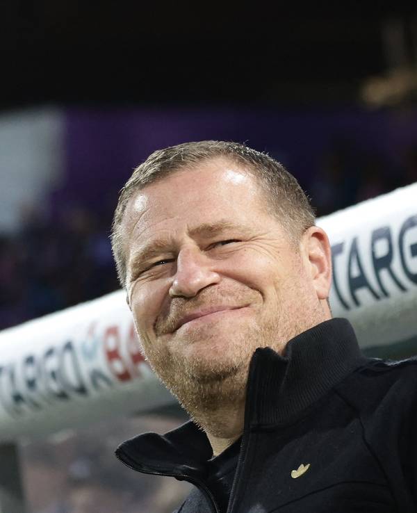 Max Eberl lächelt vor der Trainerbank.