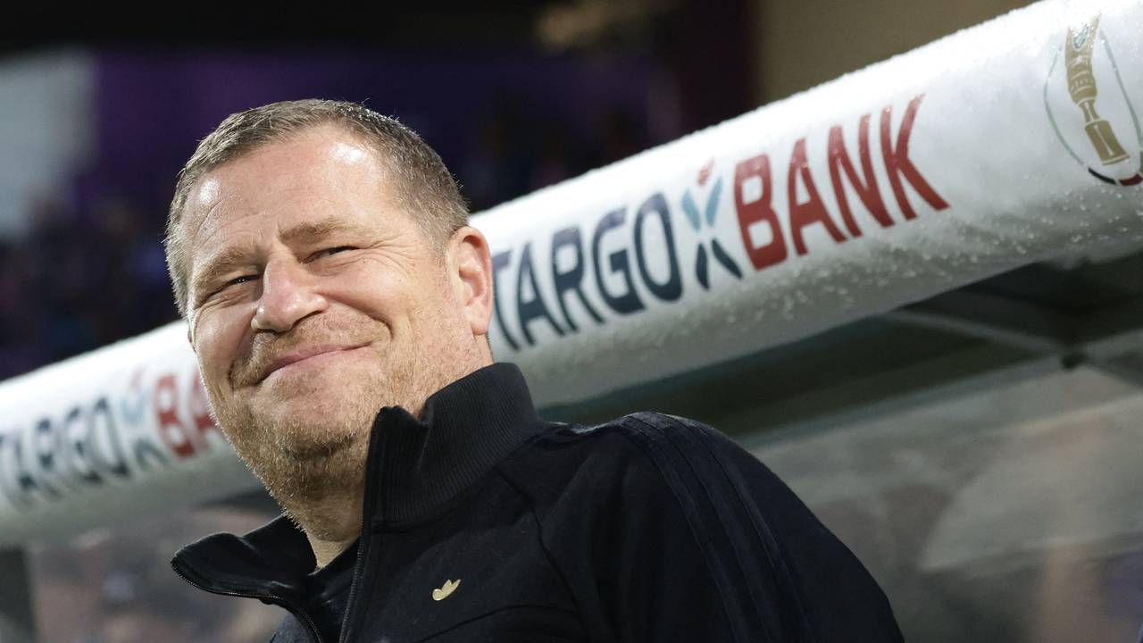 Max Eberl lächelt vor der Trainerbank.