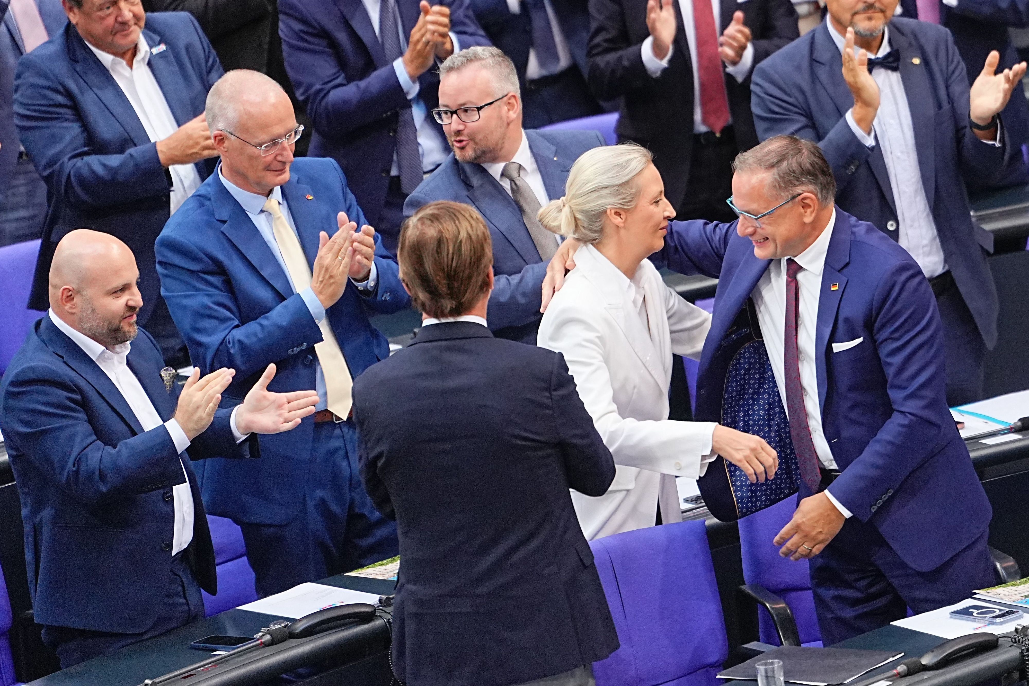 AfD-Chefin Alice Weidel wird nach ihrer Rede in der Generaldebatte im Bundestag von Tino Chrupalla (r.) und ihrer Fraktion beglückwünscht.