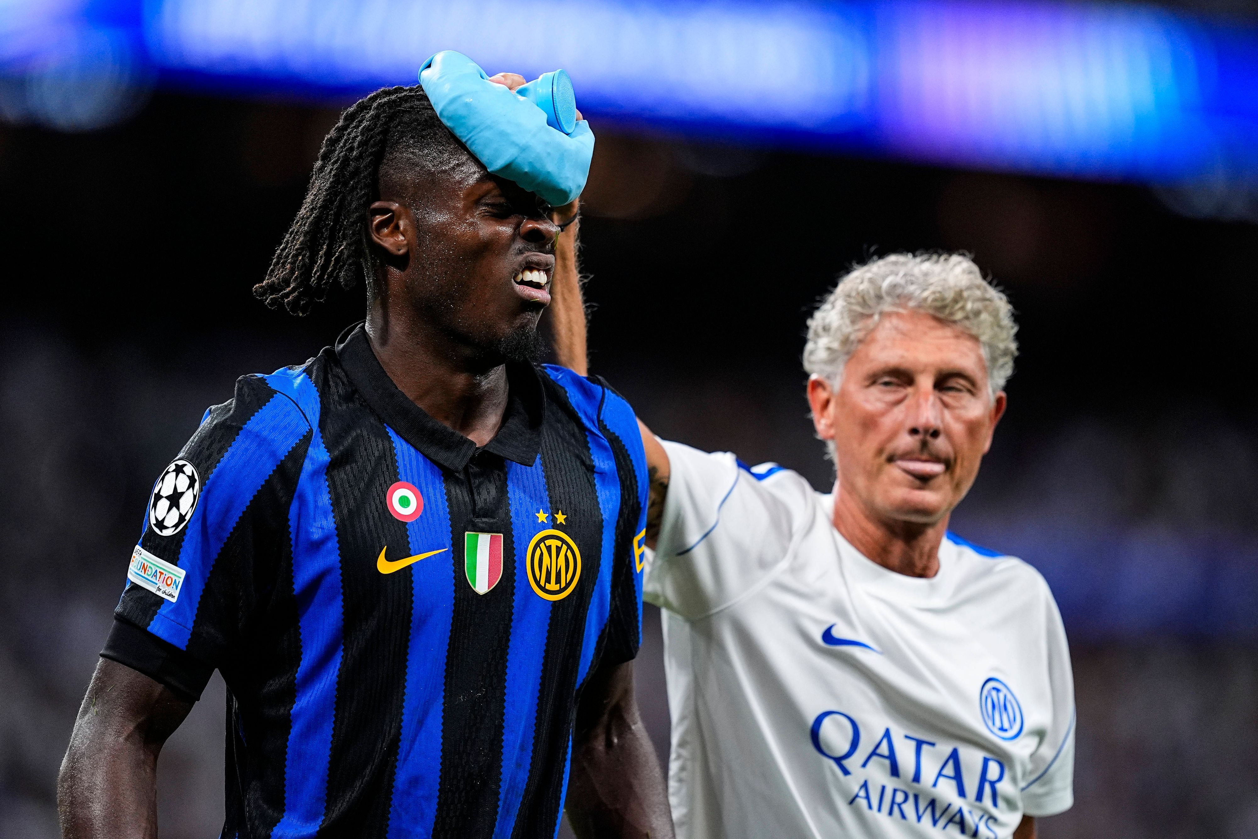Ein Betreuer von Inter Mailand kühlt den Kopf von Yann Bisseck mit Eis.