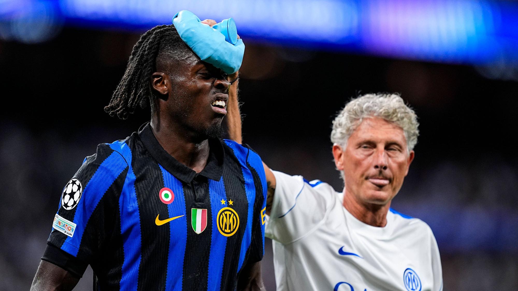 Ein Betreuer von Inter Mailand kühlt den Kopf von Yann Bisseck mit Eis.
