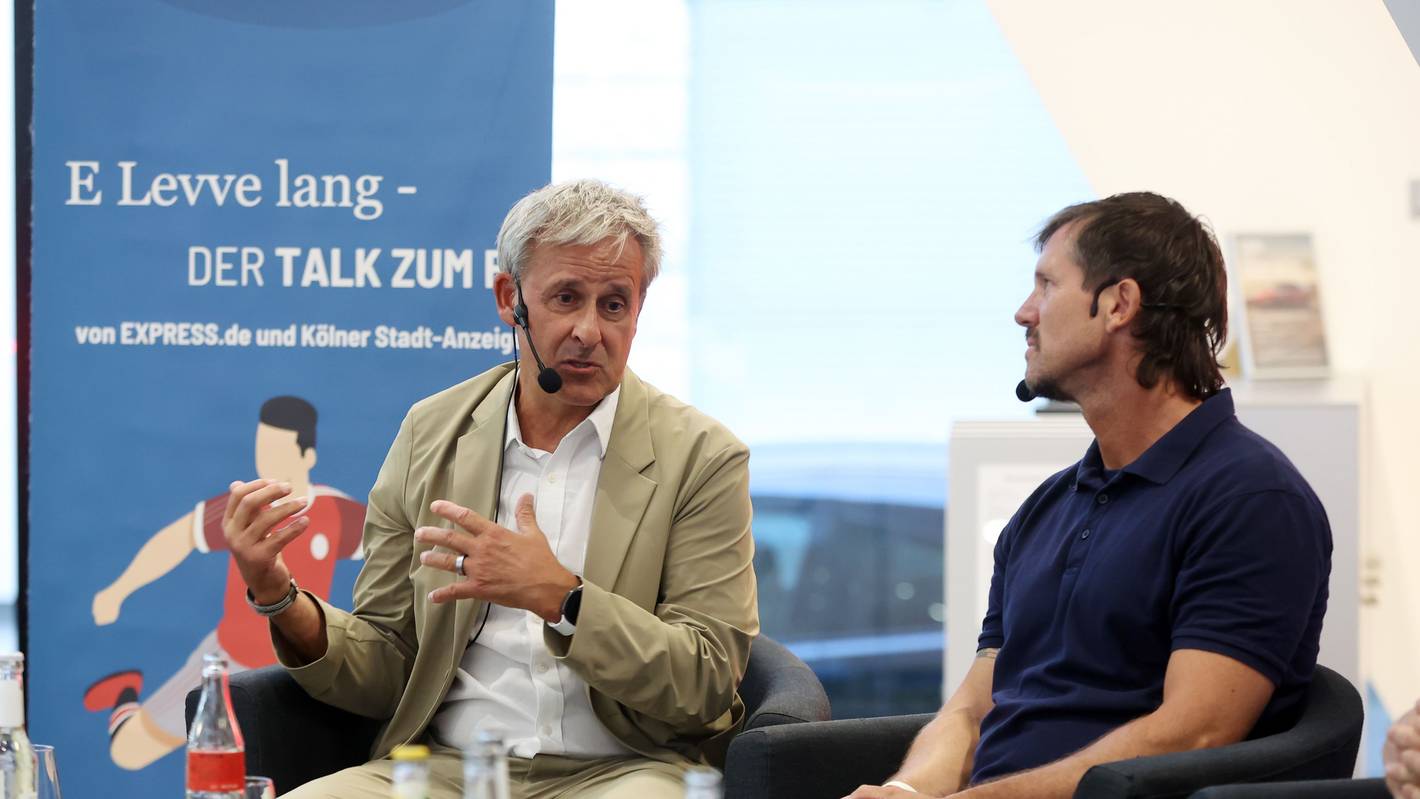 Pierre Littbarski spricht, Reporter Uwe Bödeker hört aufmerksam zu.