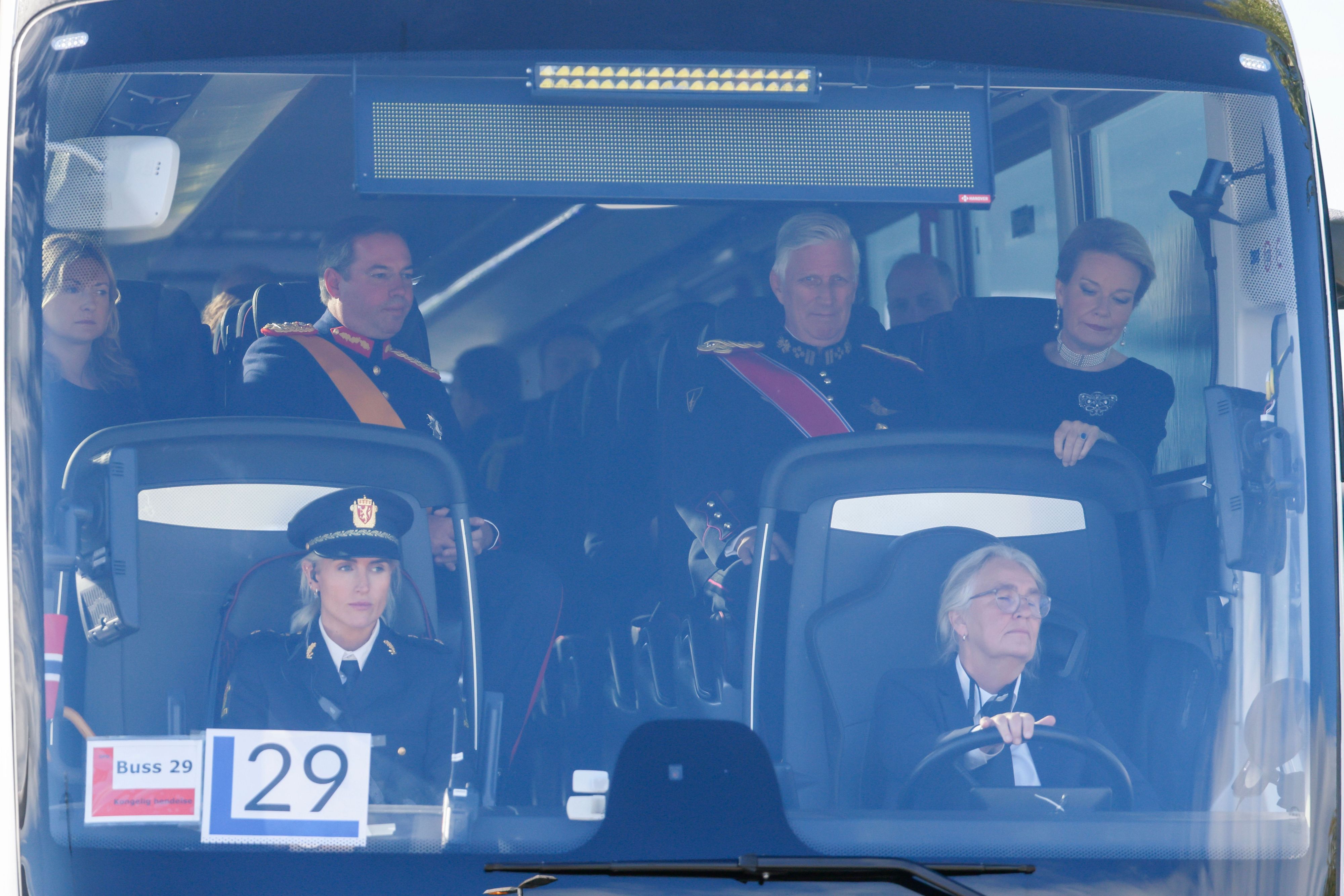 Der belgische König Philippe und Königin Mathilde (r) sitzen in einem Bus am Flughafen Oslo bei ihrer Ankunft zur Beisetzung von König Harald V. vor dem britischen Thronfolger Prinz William.