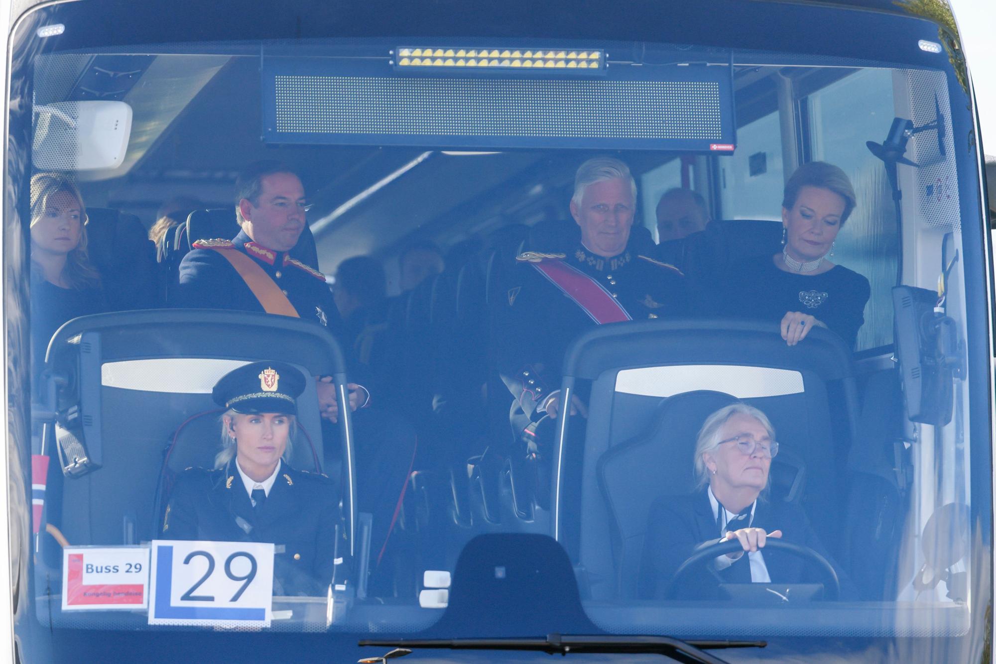 Der belgische König Philippe und Königin Mathilde (r) sitzen in einem Bus am Flughafen Oslo bei ihrer Ankunft zur Beisetzung von König Harald V. vor dem britischen Thronfolger Prinz William.
