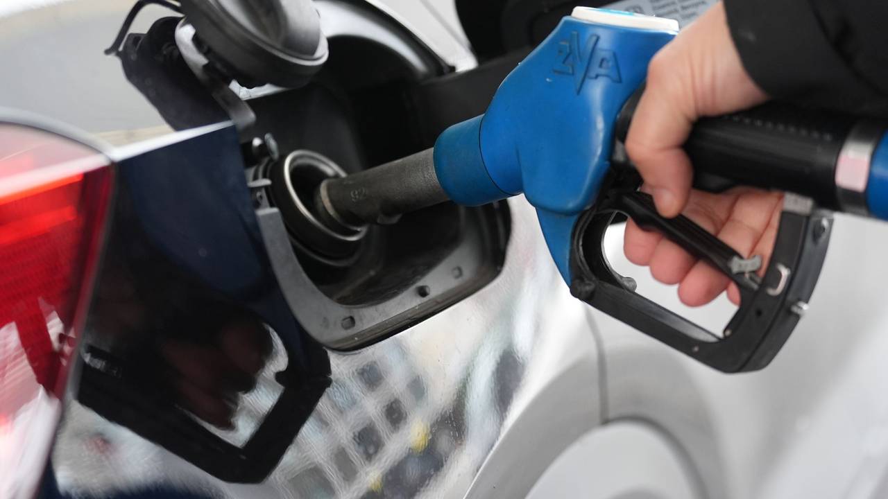 Einer Person steckt einen Zapfstutzen in den Tank eines Autos.