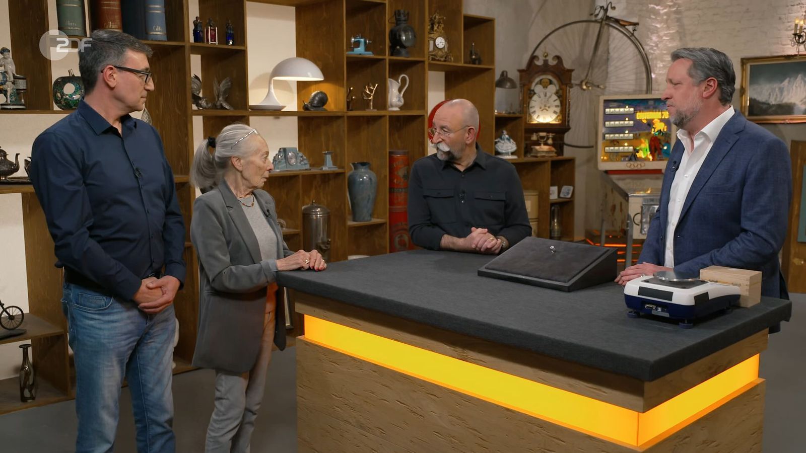 Horst Lichter (Zweiter von rechts) zeigte sich vom Funkeln der Diamanten und Brillanten des Rings beeindruckt. Doch der „Bares für Rares“-Experte Patrick Lessmann (rechts) fand eine ungeahnte Wertminderung heraus ...
 (Bild: ZDF)