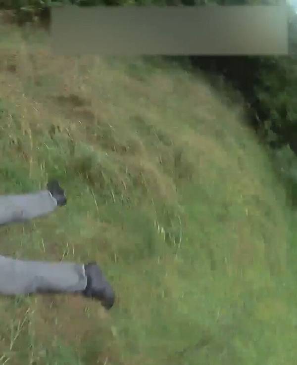 Ein Mann liegt ausgestreckt auf dem Bauch im Gras.