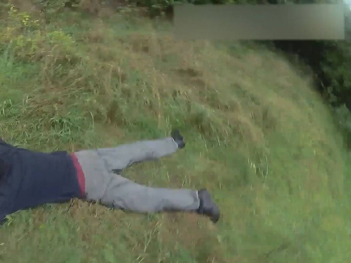 Ein Mann liegt ausgestreckt auf dem Bauch im Gras.