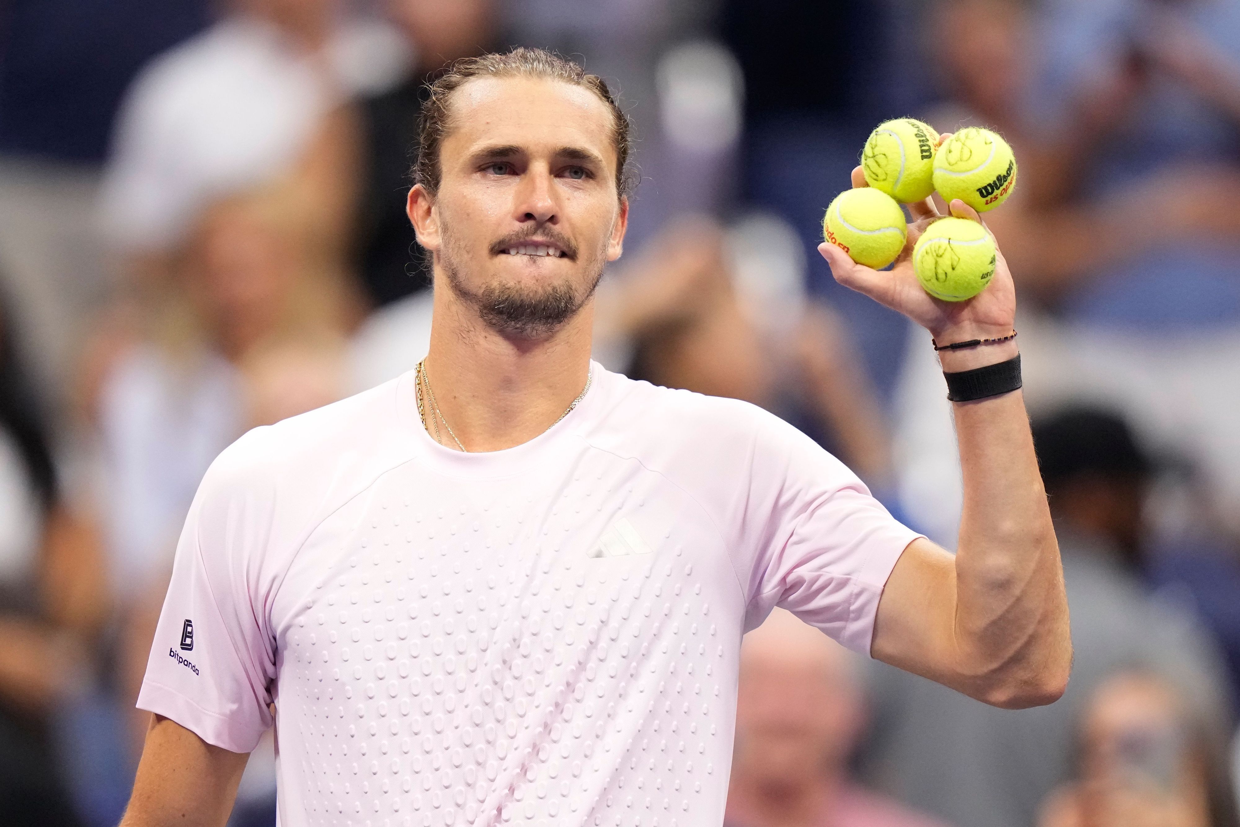 Alexander Zverev hält vier unterschriebene Bälle in der Hand, die er nun ins Publikum schießen wird.