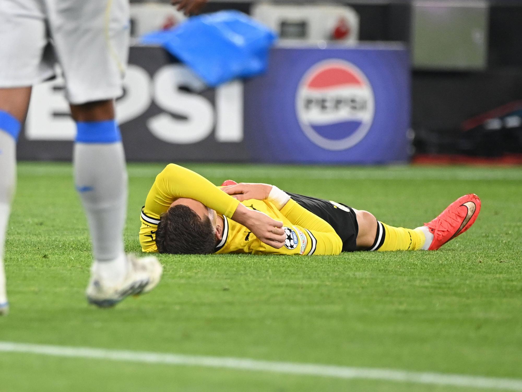 Konstantinos Karetsas liegt am Boden mit dem Arm über seinem Gesicht.