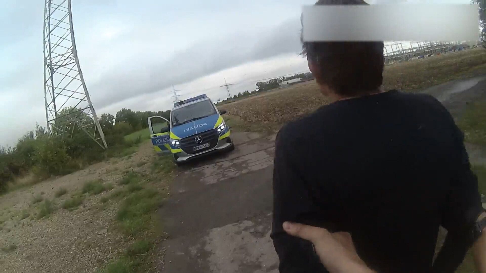 Die Bodycam eines Autobahnpolizisten zeigt wie das Versteck des tatverdächtigen Strom-Saboteurs gefunden und er verhaftet worden ist. Die Aufnahmen zeigen, wie die beiden jungen Beamten der Spur im Gras folgen und im Gebüsch rund 200 Meter neben dem Weg auf einen Mann stoßen.