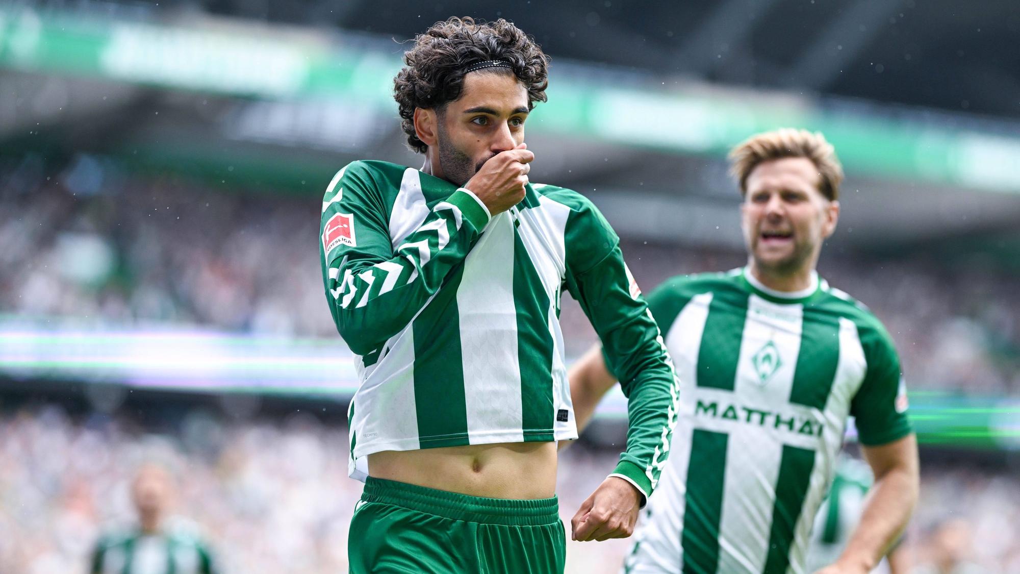 Nach einem Tor für Werder Bremen jubelt Eren Dinkci und küsst das Werder-Wappen auf dem Trikot.