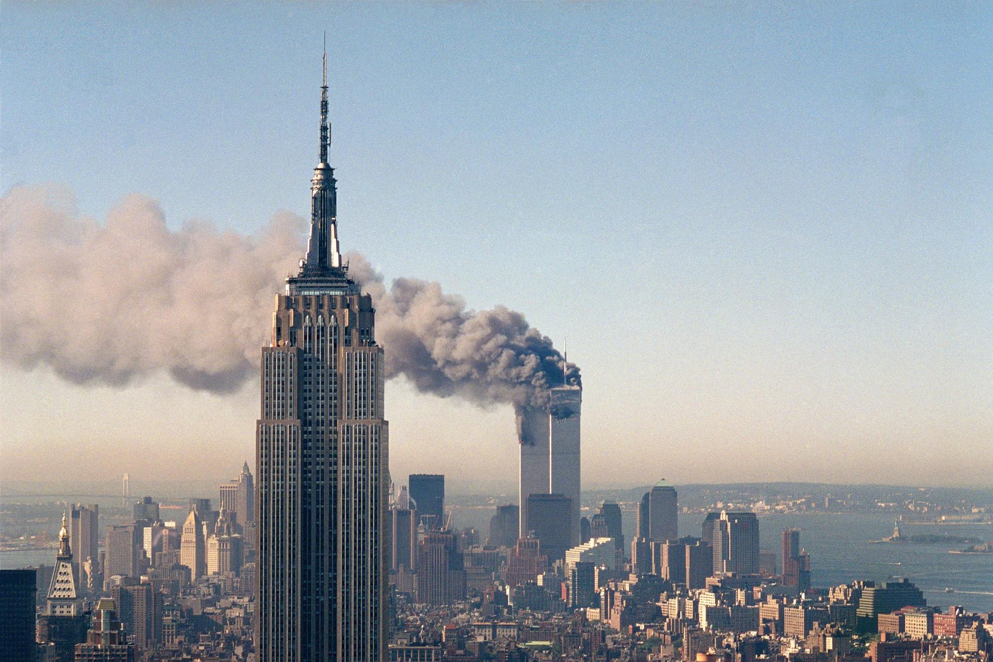 Die Zwillingstürme des World Trade Centers brennen hinter dem Empire State Building.