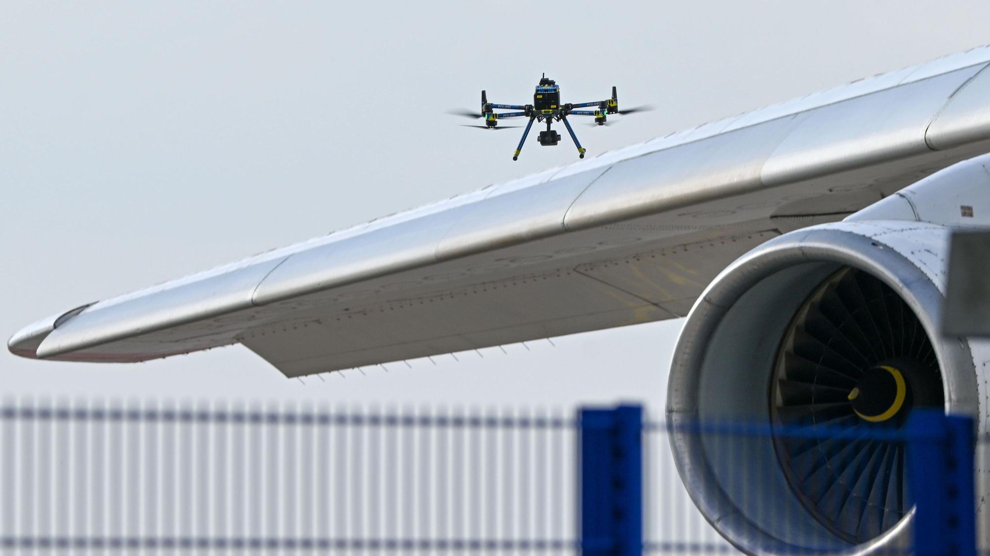 Eine Drohne der Polizei ist über einer Flugzeugtragfläche zu sehen.