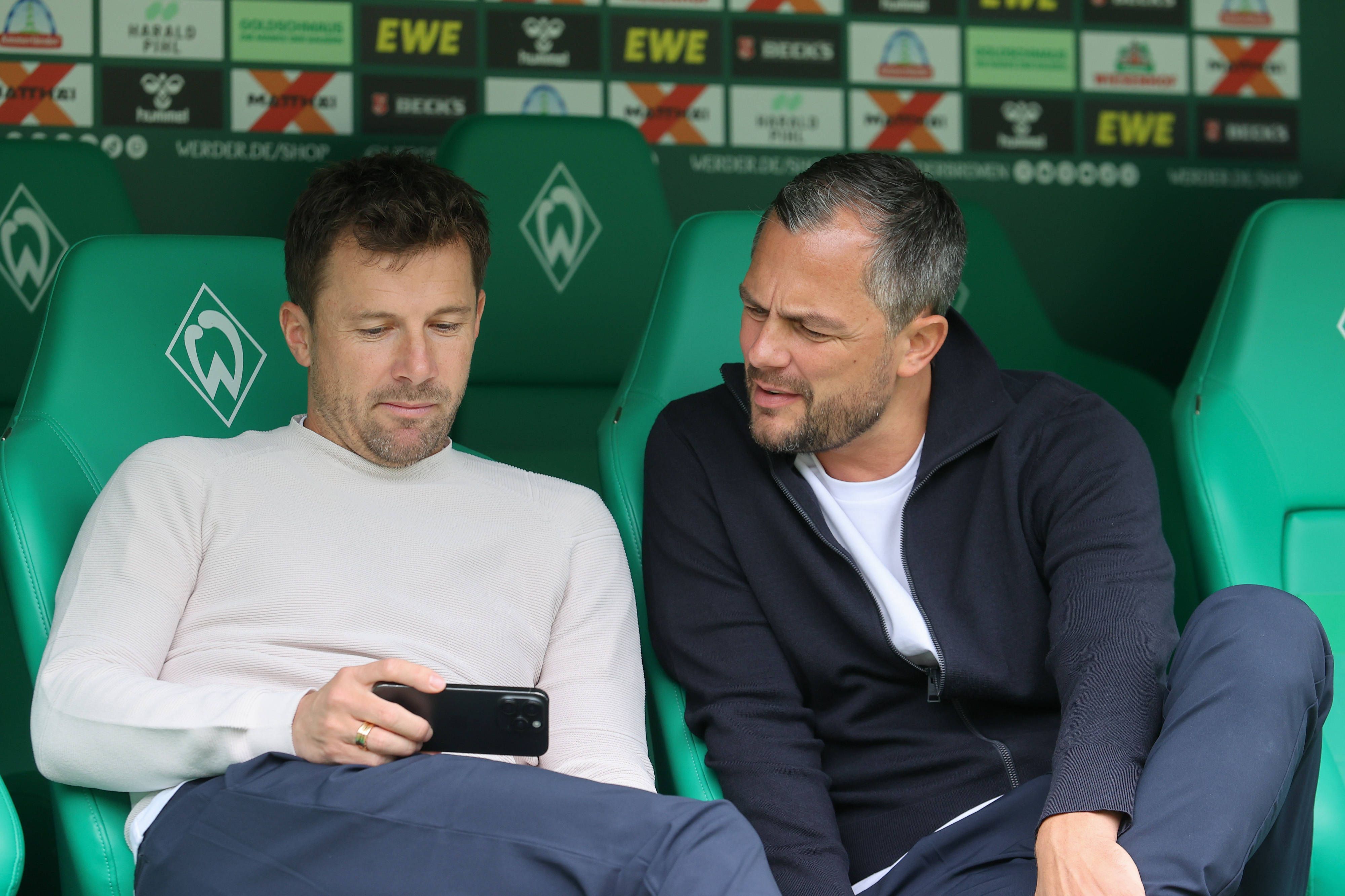 Daniel Baier und Marcel Schäfer gucken auf ein Handy.