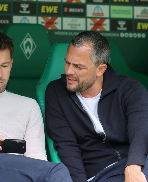 Daniel Baier und Marcel Schäfer gucken auf ein Handy.