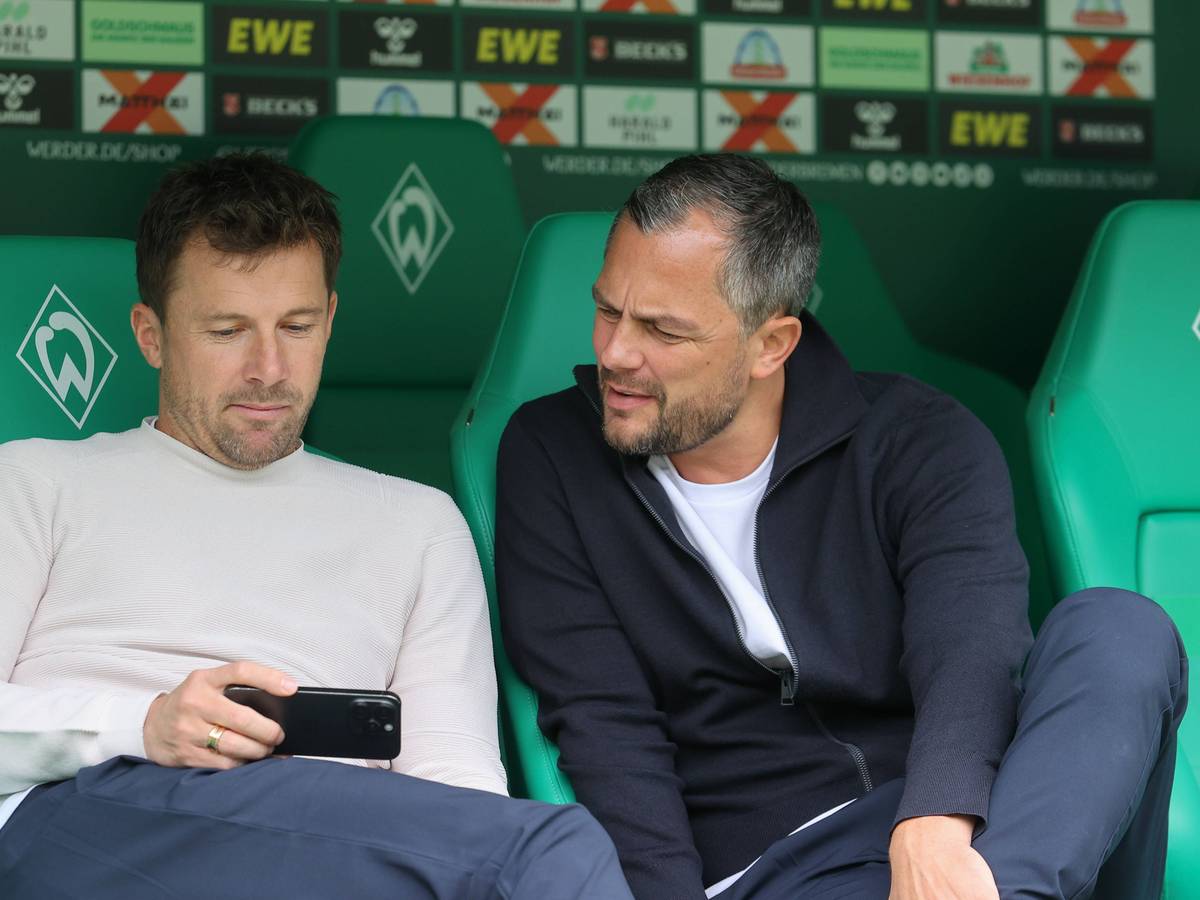 Daniel Baier und Marcel Schäfer gucken auf ein Handy.