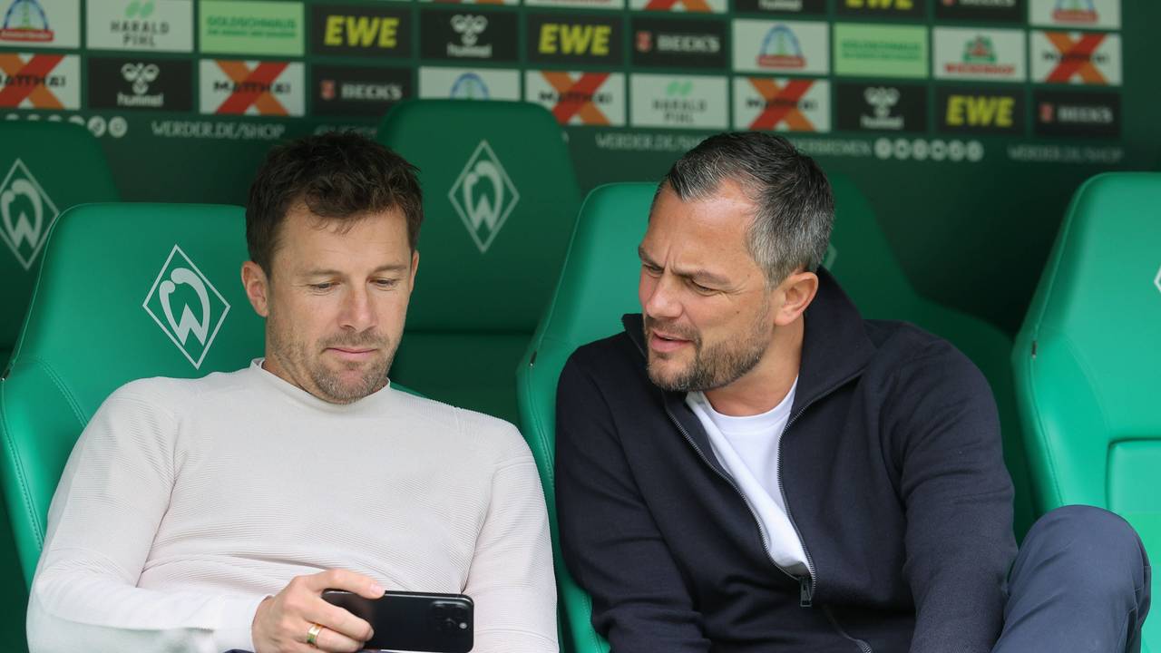 Daniel Baier und Marcel Schäfer gucken auf ein Handy.