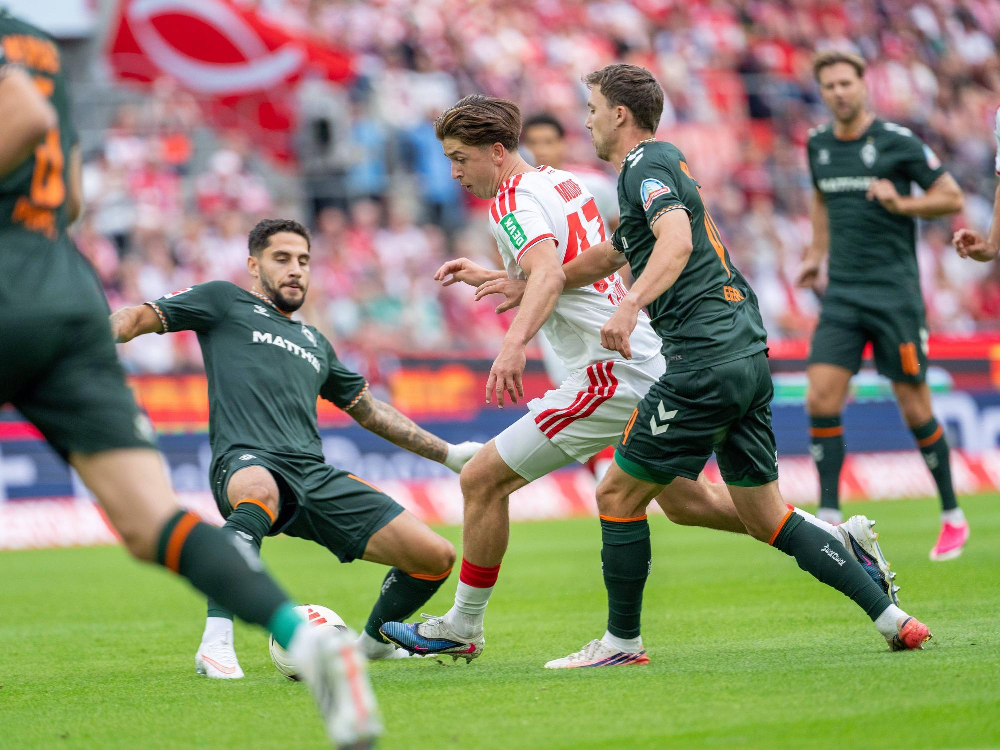Ludovit Reis (SV Werder Bremen) grätscht gegen Mikey Moore (1. FC Köln).
