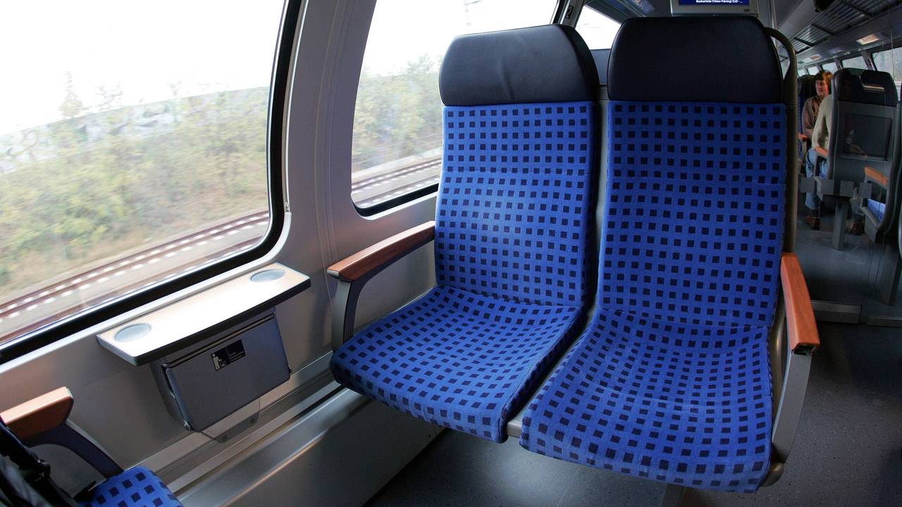 Zugabteil mit Sitzen und einem Fahrgast