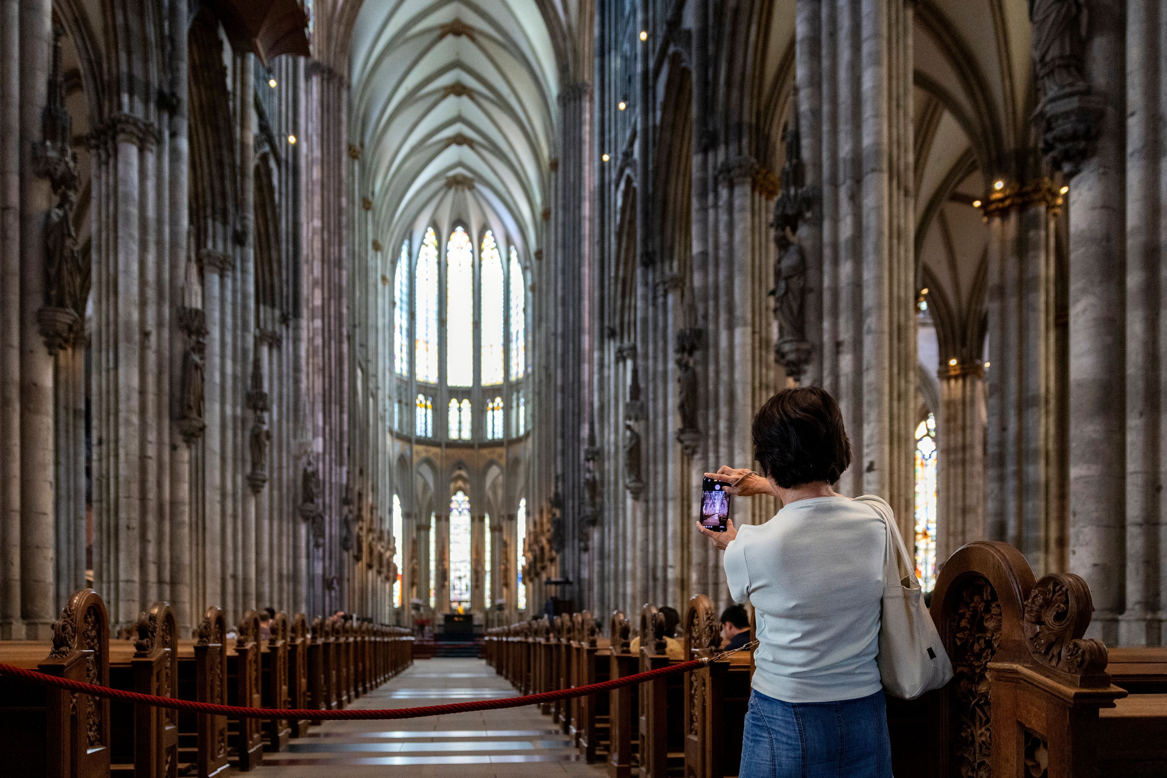Eine Frau fotografiert im Kölner Dom.
