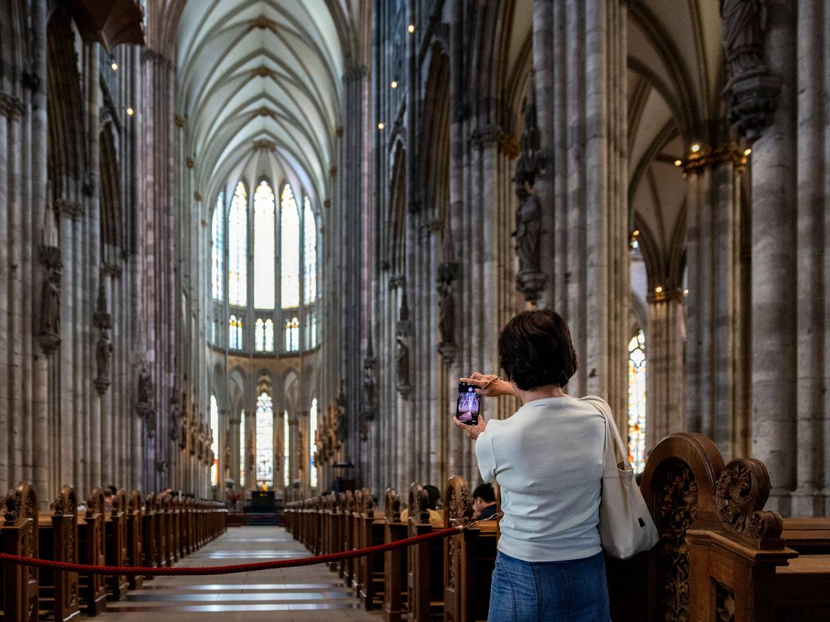 Eine Frau fotografiert im Kölner Dom.