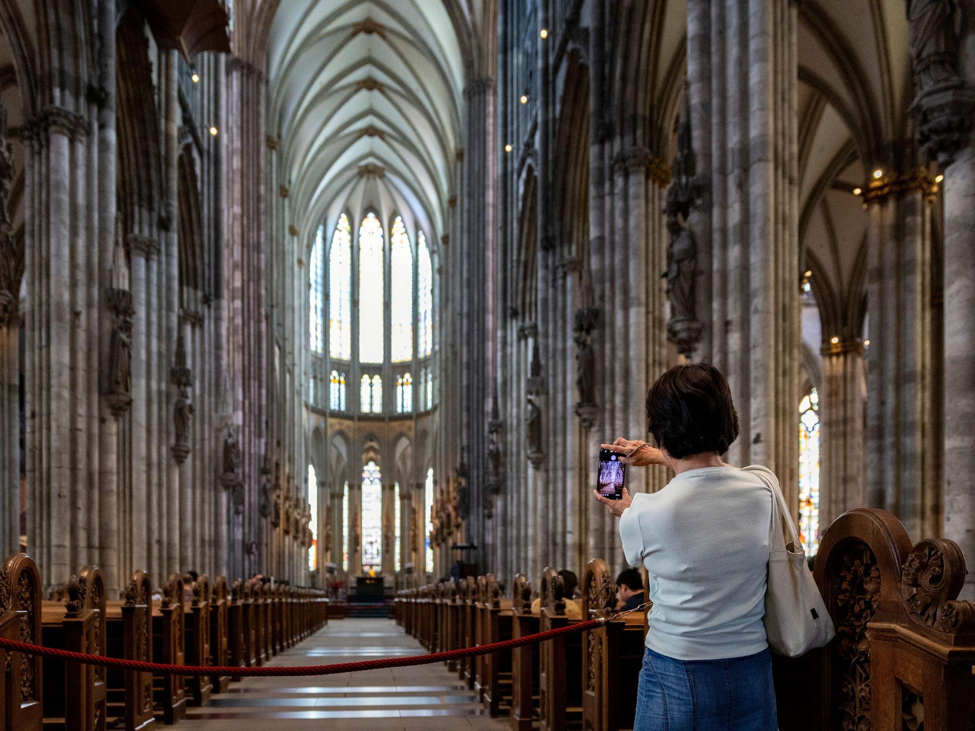 Eine Frau fotografiert im Kölner Dom.