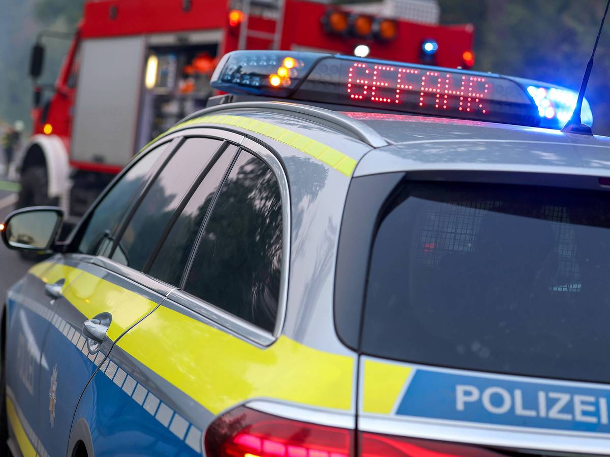 Polizeiauto und Feuerwehrauto mit Blaulicht, Aufschrift Gefahr