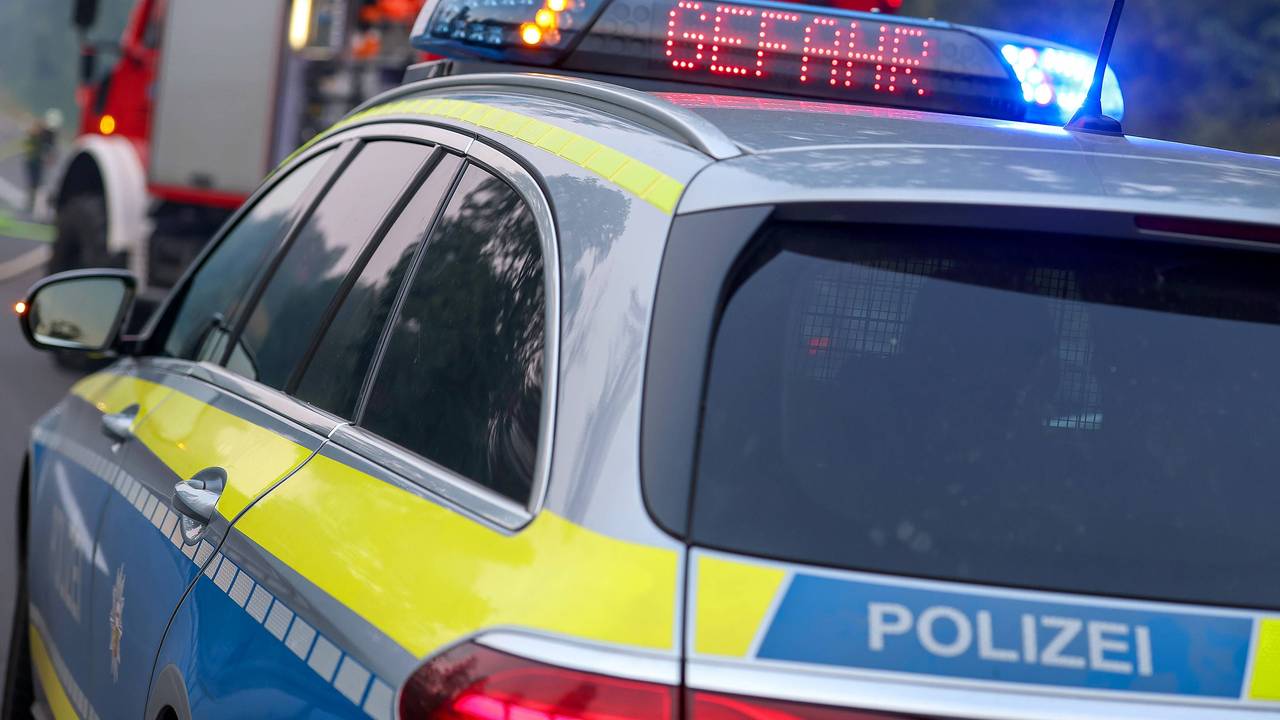 Polizeiauto und Feuerwehrauto mit Blaulicht, Aufschrift Gefahr