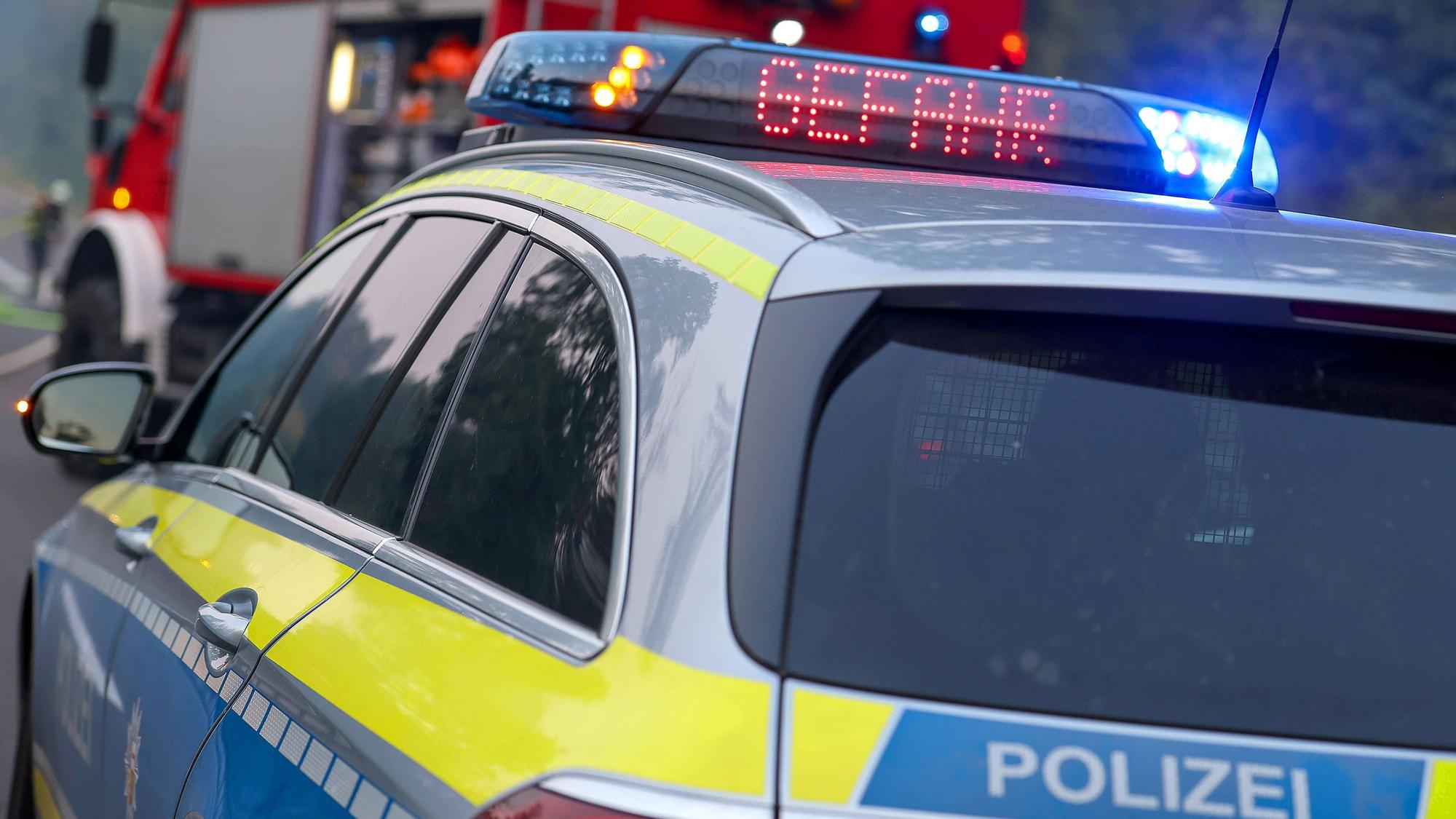 Polizeiauto und Feuerwehrauto mit Blaulicht, Aufschrift Gefahr