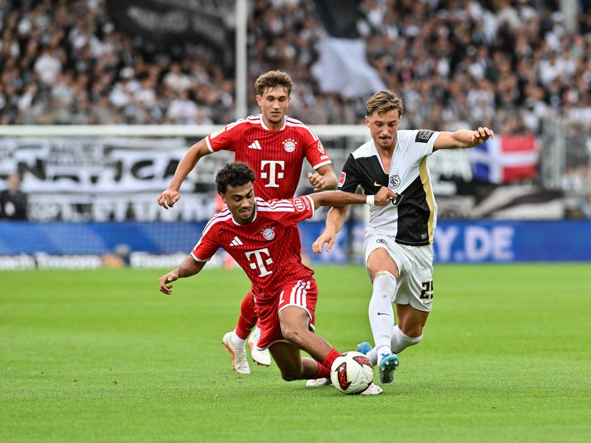 Nathaniel Brown geht gegen Lukas Petkov ins Tackling. Tom Bischof schaut dahinter zu.