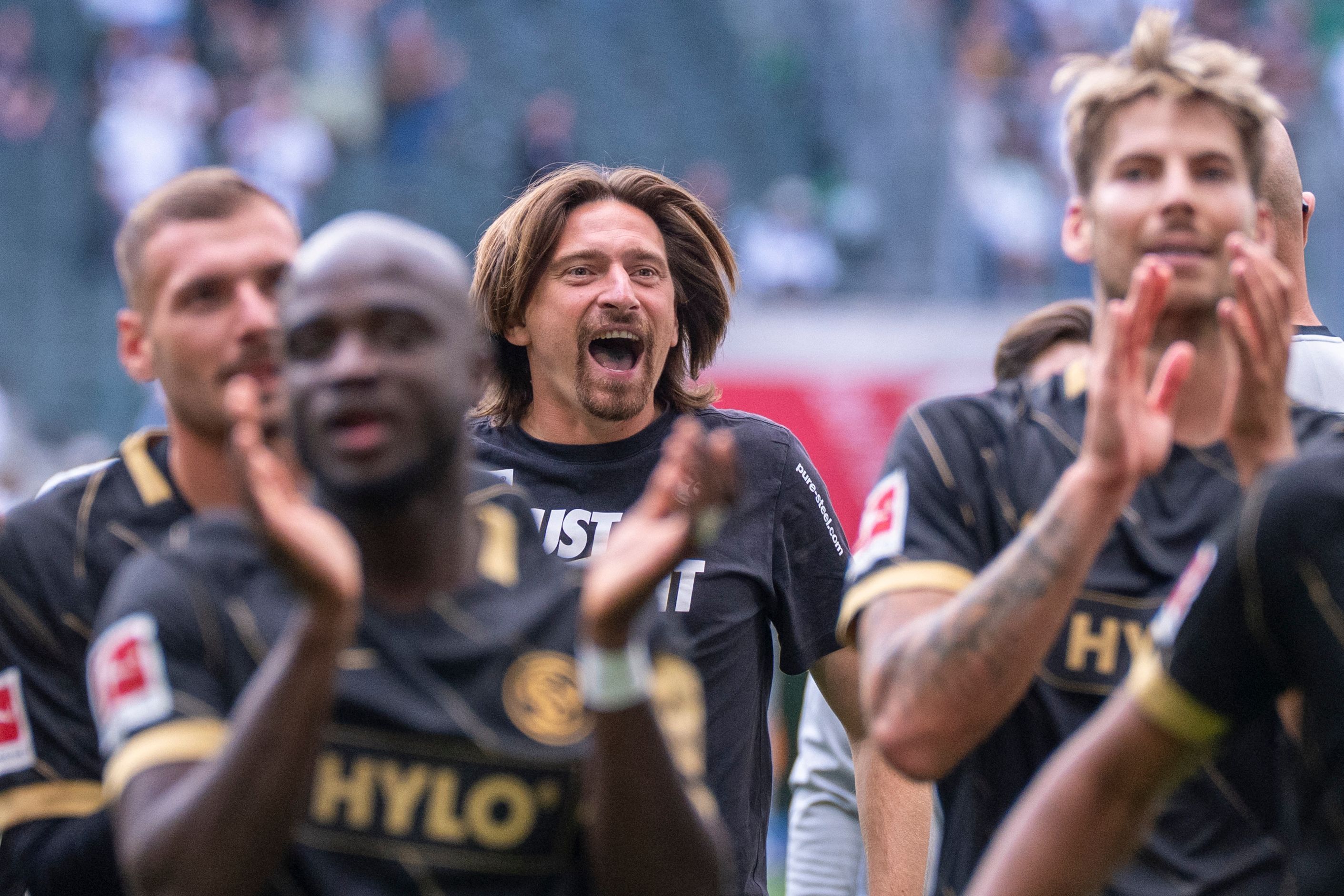 Trainer Vincent Wagner (M, SV 07 Elversberg) jubelt nach dem Schlusspfiff mit seinen Spielern über den Sieg in Gladbach.