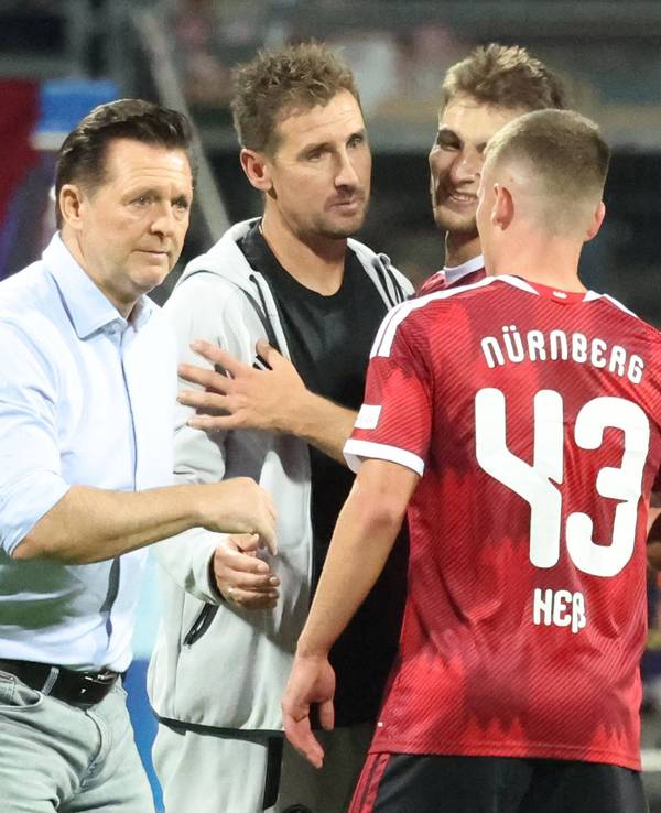Christian Titz und Miroslav Klose klatschen einen Spieler ab.
