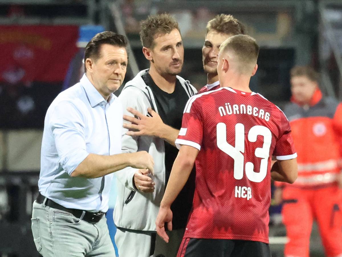 Christian Titz und Miroslav Klose klatschen einen Spieler ab.