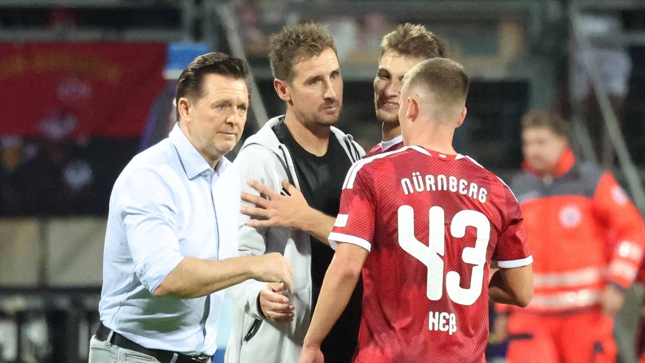 Christian Titz und Miroslav Klose klatschen einen Spieler ab.