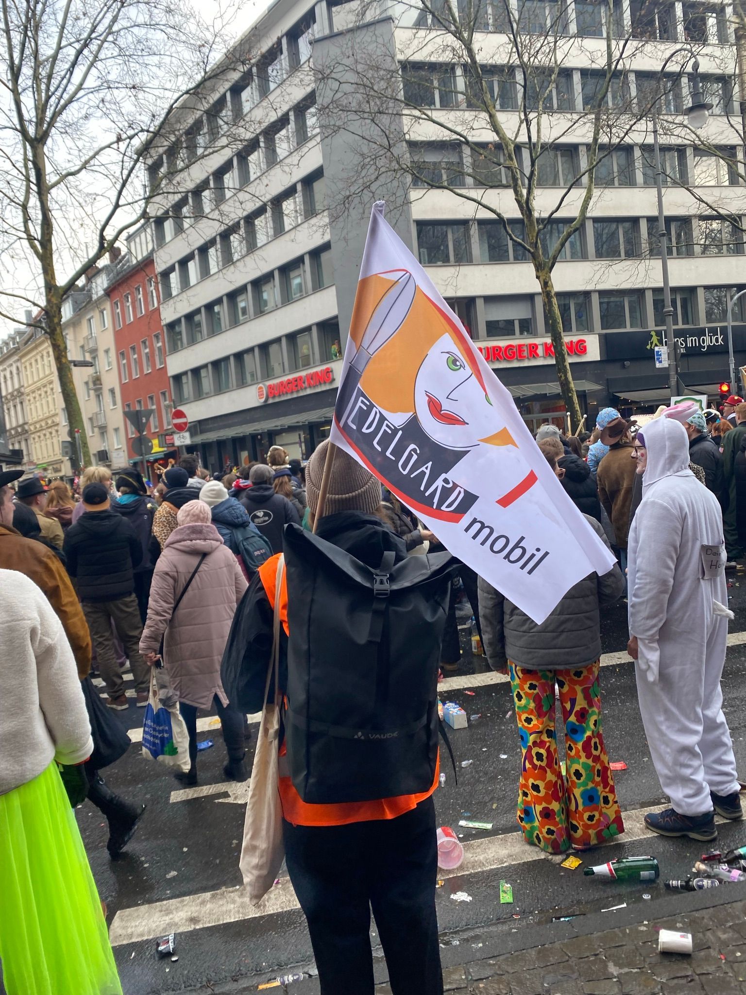 Eine Frau steht mit einer Edelgard-Flagge in einer Menge.