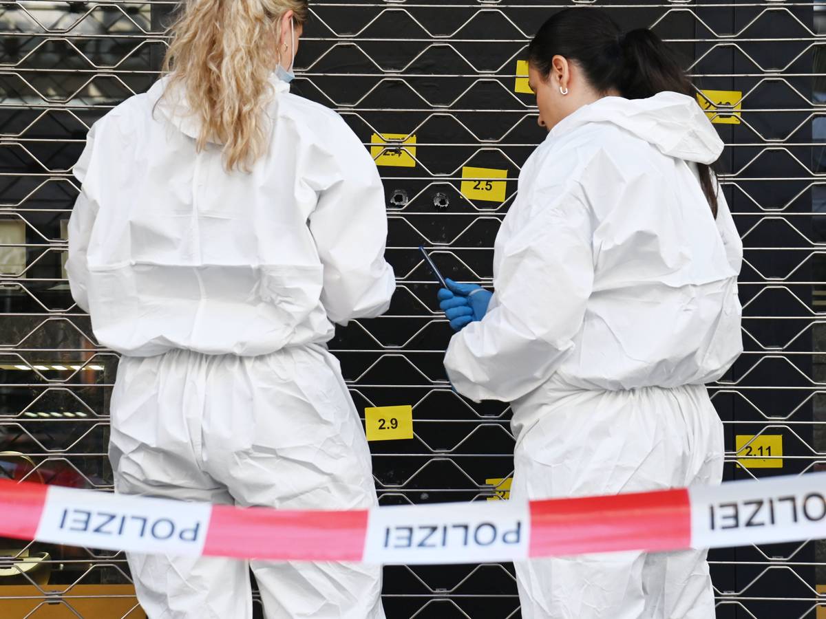 Zwei Beamtinnen sichern an einer Scheibe, in der mehrere Einschlusslöcher klaffen, Spuren.