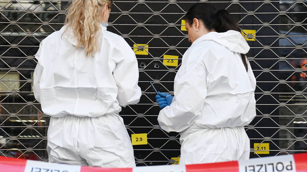 Zwei Beamtinnen sichern an einer Scheibe, in der mehrere Einschlusslöcher klaffen, Spuren.