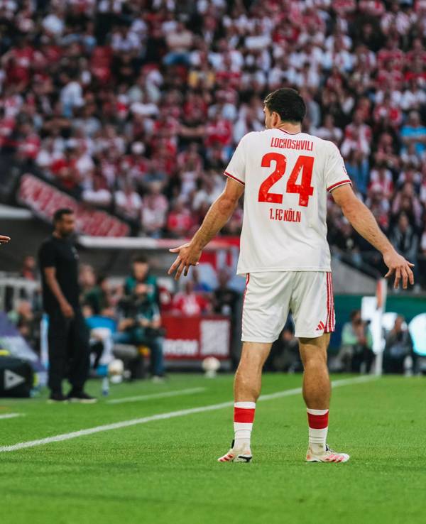 René Wagner (1. FC Köln) spricht mit Verteidiger Luka Lochoshvili, der mit den Schultern zuckt.