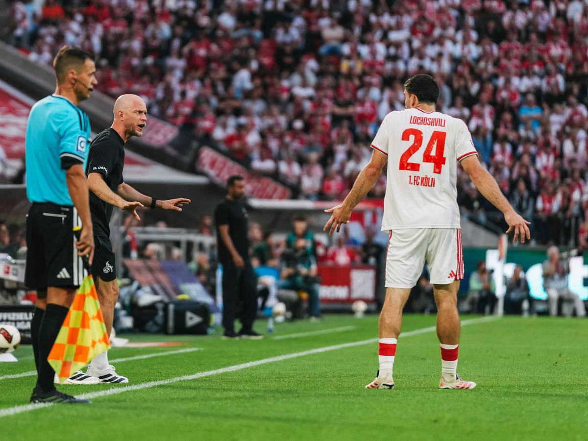 René Wagner (1. FC Köln) spricht mit Verteidiger Luka Lochoshvili, der mit den Schultern zuckt.