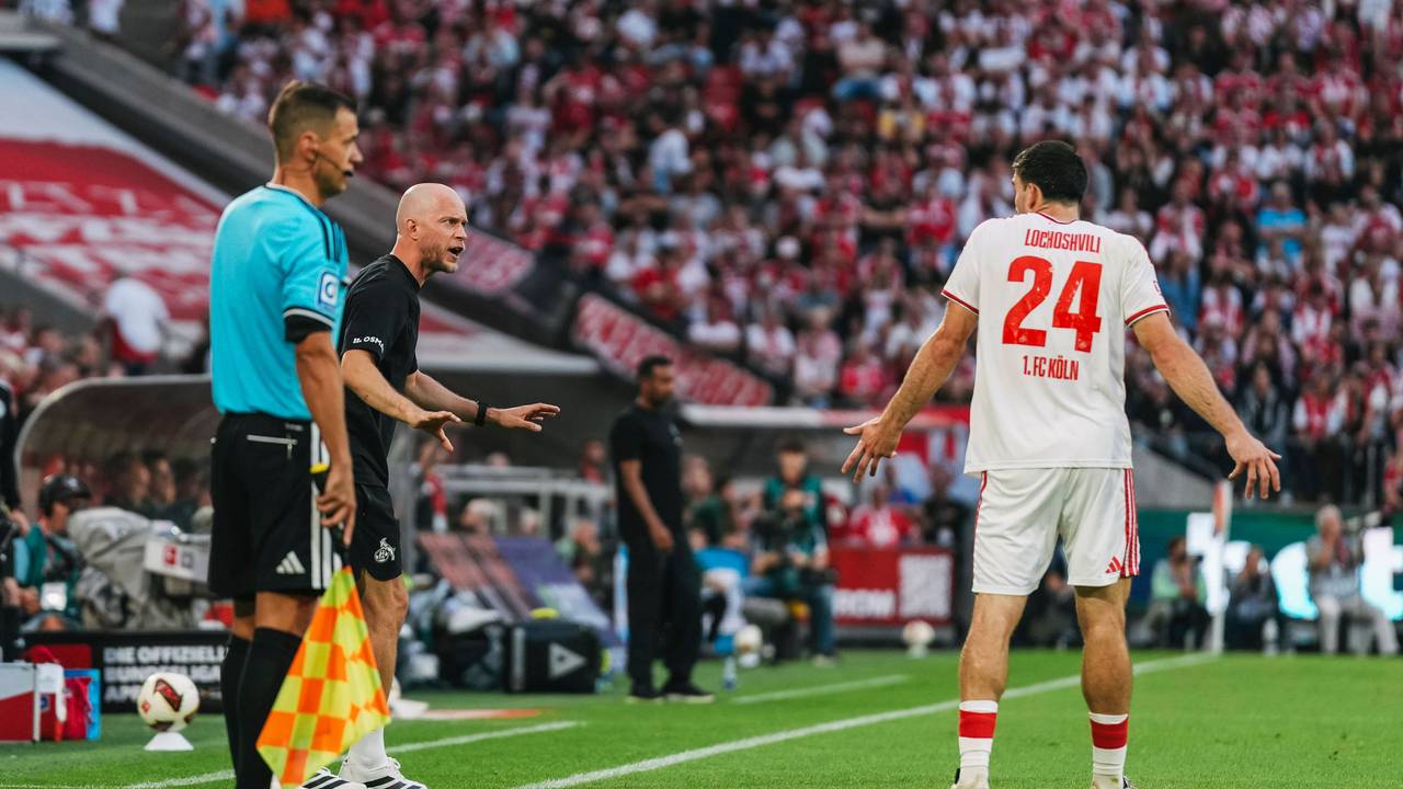 René Wagner (1. FC Köln) spricht mit Verteidiger Luka Lochoshvili, der mit den Schultern zuckt.