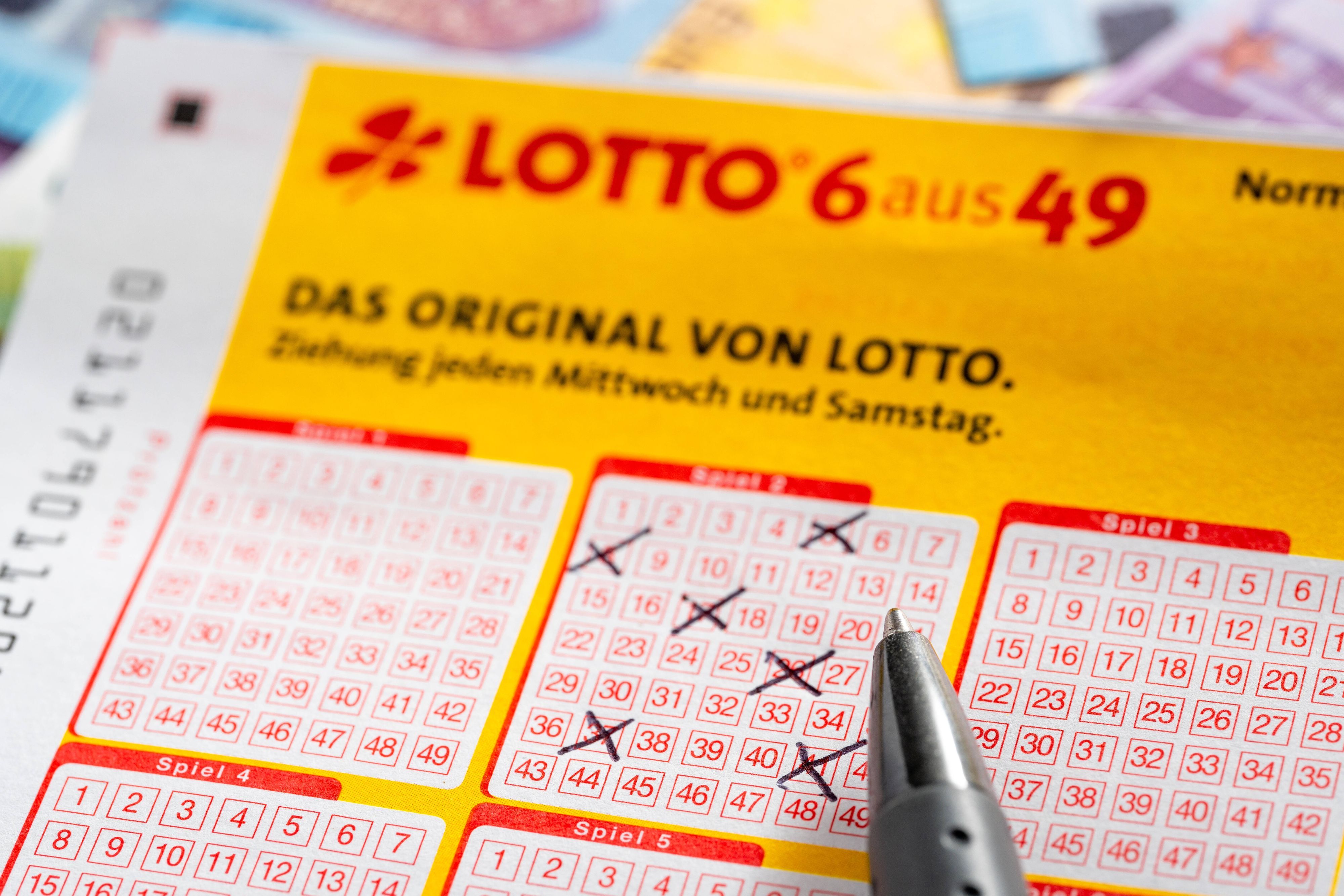 Lotterieschein, Stift und Geld