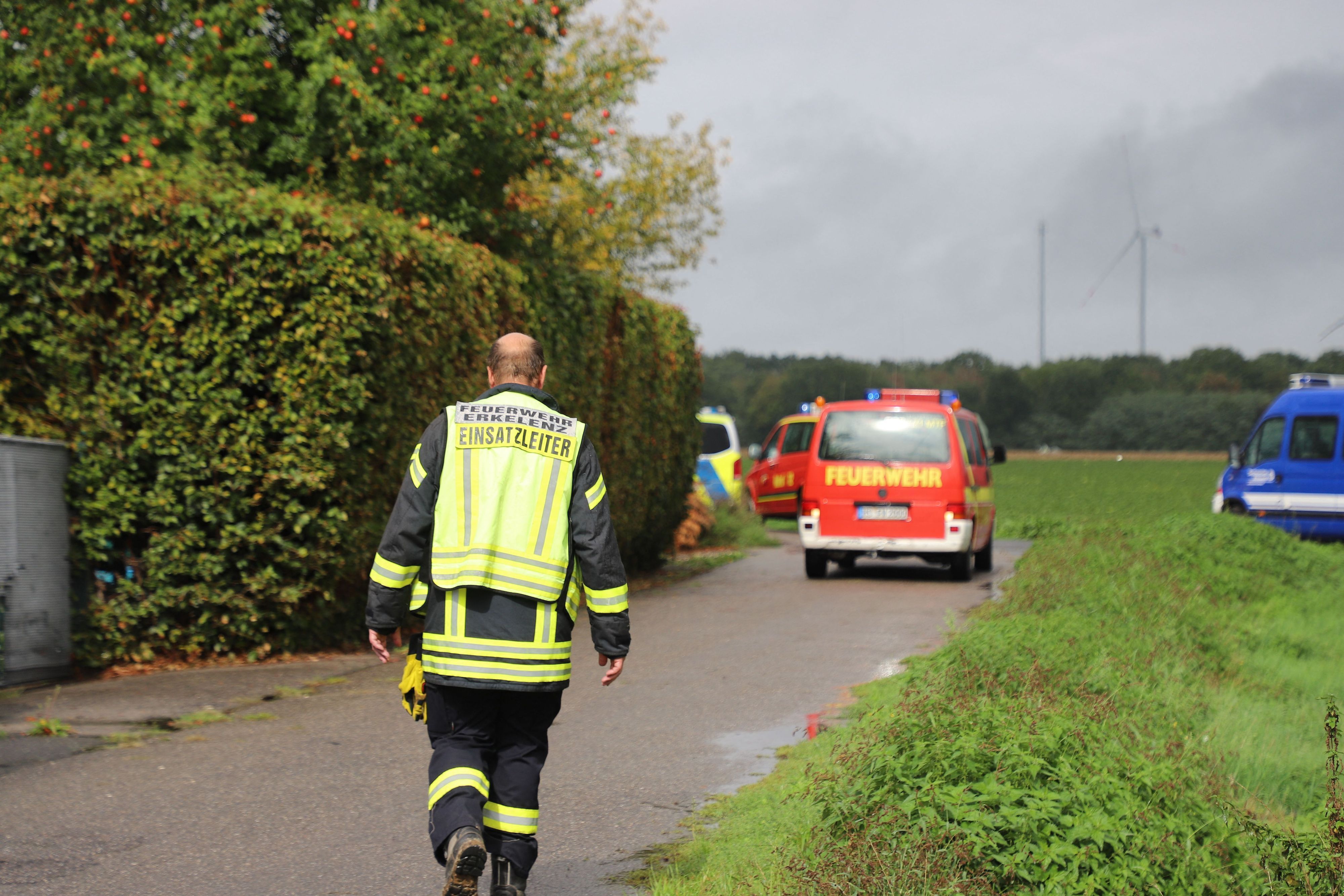 Der Einsatzleiter der Feuerwehr geht in Richtung des Absturzortes des Kleinflugzeugs in Erkelenz.