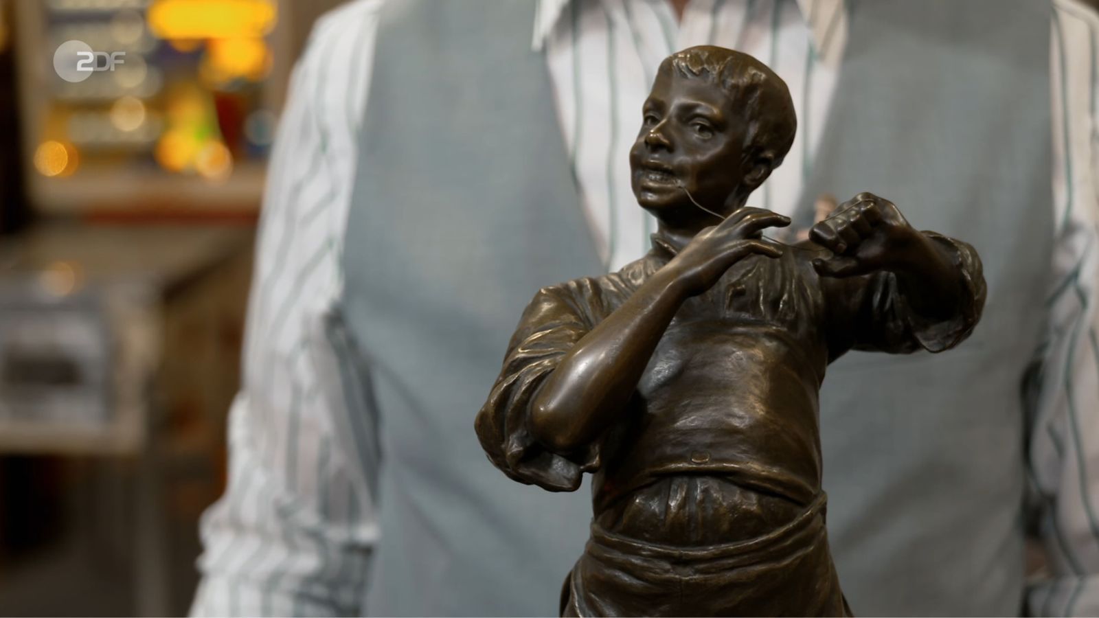 „Der will sich einen Zahn ziehen“, vermutete Lichter. Die Händler fragten sich, ob der Junge angelte, Flöte spielte oder Zahnseide benutzte. Silvio erklärte: Die Bronze-Statuette hieß „Der Saitenspieler“. Friedrich Häusser bezahlte 2.100 Euro - 100 über der Expertise. (Bild: ZDF)