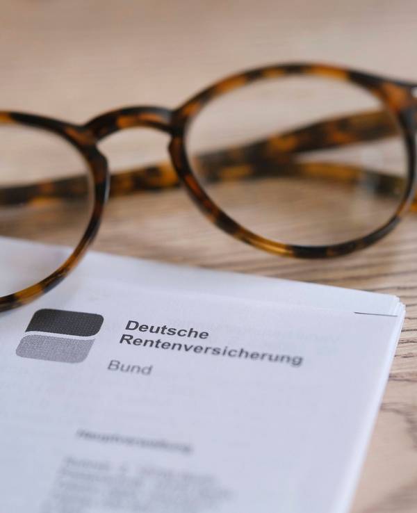 Smartphone, Brille und Rentendokument