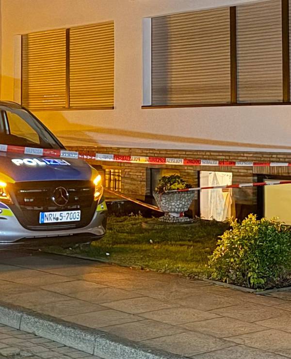 Ein Polizeifahrzeug steht vor einem Haus.