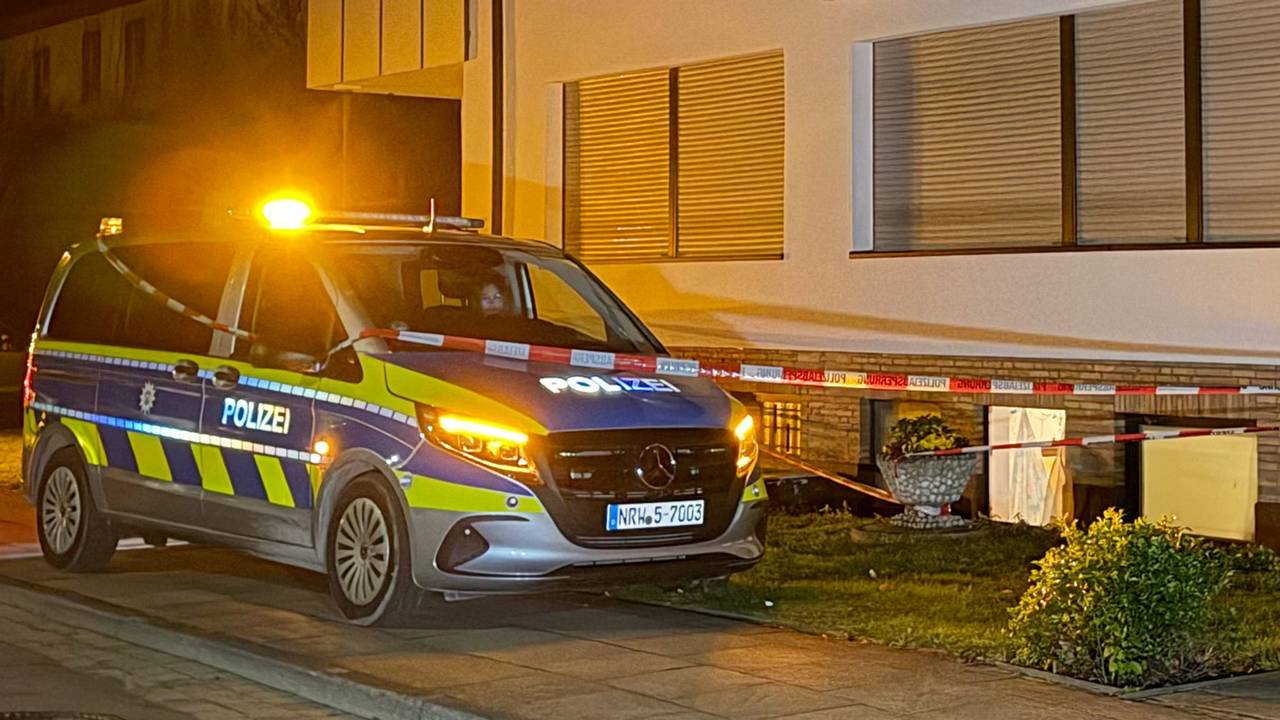 Ein Polizeifahrzeug steht vor einem Haus.